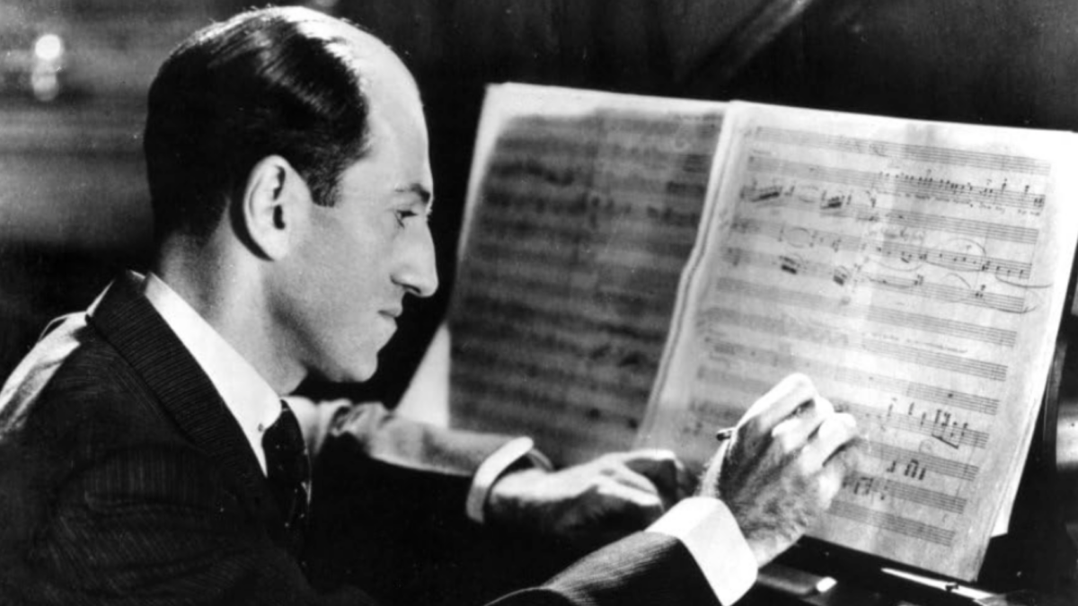 George Gershwin seated at piano